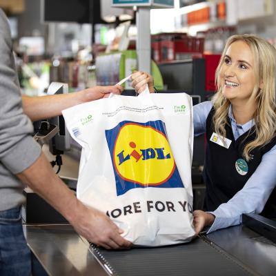 Woman handing a Lidl bag to a customer