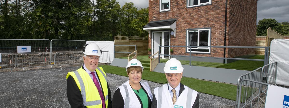 Eugene Lynch, Managing Director of The McAvoy Group, Clare McCarty, Group Chief Executive at Clanmil Housing and David Orr, Chief Executive of the National Housing Federation in front of a prototype house at Clanmil's site in Carrickfergus, where 40 new social homes will be the first in Northern Ireland delivered using off-site construction.