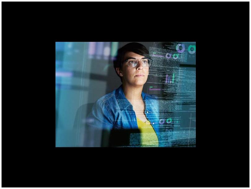 woman looking through a clear screen with data reflected on it