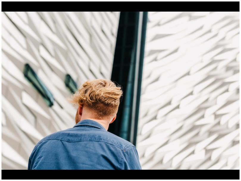 Man in denim shirt facing the Titanic Museum