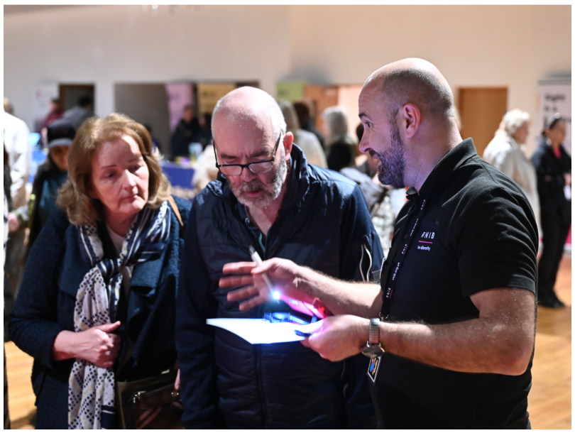 RNIB staff member demonstrated electronic magnifier to two visitors at last year's Technology Fair