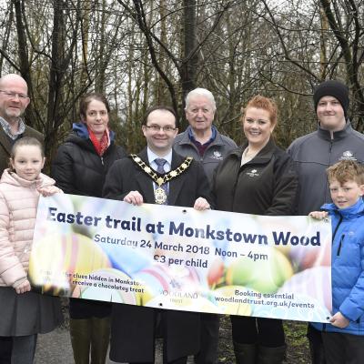 Funders and local people inspect the site improvements at Monkstown Wood.  They are pictured holding up an 'Easter Trail' banner.